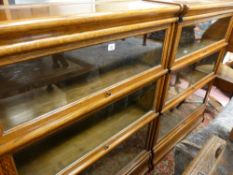 A PAIR OF GLOBE WERNICKE THREE SECTION LIGHT OAK STACKING BOOKCASES with labels, 115.5 cms high,