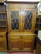AN ANTIQUE WELSH OAK TWO PIECE CUPBOARD with upper glazed doors, twin frieze drawers and lower