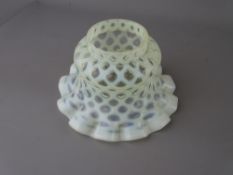 A VASELINE GLASS LAMPSHADE with frilly edge, 15.5 cms diameter maximum