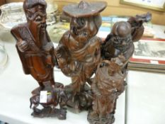 Four Oriental carved figures and a similar horse