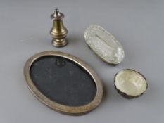 Four items of small silver including an oval portrait frame, a pepper pot, a small embossed bowl