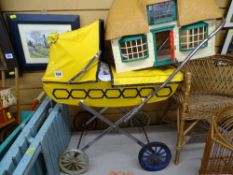 Child's vintage toy pram and a toy thatched roof cottage