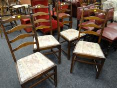 A set of four Ercol dark oak ladder back drop in cushion dining chairs