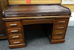A roll-top desk with low tambour, four single drawers to left bank, three single and one double