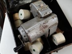 A vintage bus conductor's ticket machine in tin box & with ticket reels