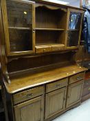 A modern light oak kitchen dresser, upper glazed cupboards above a three-door base