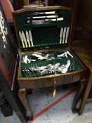 A vintage mahogany cased canteen of cutlery in a raised cabinet
