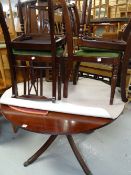 A modern reproduction mahogany extending circular dining table together with four matching cushion