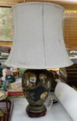 A ceramic gilt & black painted table lamp decorated with Oriental heads