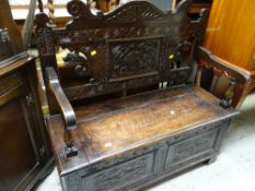 A carved oak box seat monk's bench