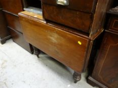 A vintage mahogany drop leaf dining table with reeded legs on castors
