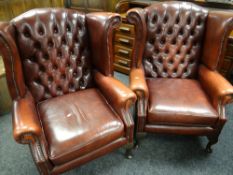 A pair of modern red leather button & wingback armchairs