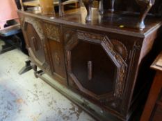A vintage bow fronted carved decorated oak sideboard on raised feet