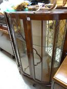 A vintage bow fronted mahogany effect display cabinet