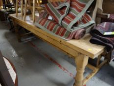 A substantial pine plank top kitchen table together with ten pine loose cushion chairs