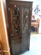 A dark oak Old Charm-style lead glass door top standing corner cupboard