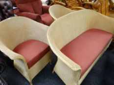 A modern Lloyd Loom lounge suite in gold with wine coloured fabric cushions, comprising sofa & two