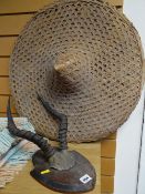 Pair of shield mounted antler horns together with a Chinese wicker hat