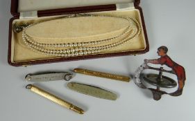 A vintage metallic toy acrobat, two advertising fruit knives & two similar advertising pencils,