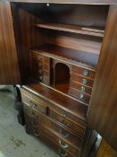 A reproduction mahogany gentleman's chest of drawers with a desk top