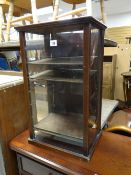 A small glass & shelved counter display cabinet