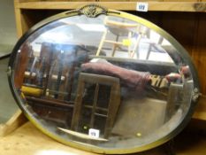 A vintage oval metal framed & decorated bevel glass wall mirror
