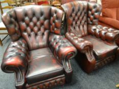 A pair of antique red leather button & wing back armchairs