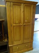 A modern pine two-door wardrobe above a single drawer base