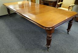 A Victorian mahogany dining table with three centre leaves on four fluted tapering supports,