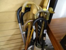 Selection of canes and umbrellas including an ebonized example with silver mounts