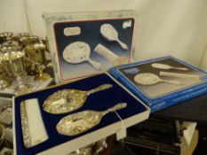 Two boxed three piece silver plated dressing table sets