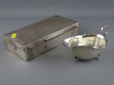 Rectangular silver cigarette box and a three footed gravy boat, both hallmarked