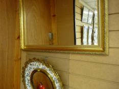 Decorative circular wall mirror with bird and floral painted frame and a gilt framed bevelled wall