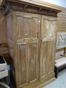 A large partially stripped mahogany two-door wardrobe