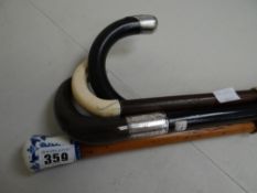 Three walking sticks & a walking cane, two with hallmarked silver mounts