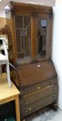 A vintage bureau bookcase with decorated lead glazed doors