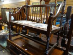 A small dark wood spindle back two-seater bench together with an occasional table