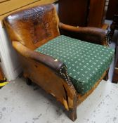 A distressed antique leather armchair with studded decoration