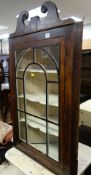 An antique three-shelf mahogany hanging corner cupboard