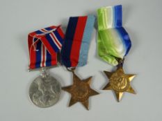 Three WWII medals in box with newspaper clipping