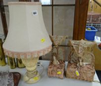 A pair of early twentieth century doll table lamps both 'sat up in bed' with silk bed-clothes and