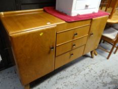A vintage walnut veneered sideboard, two cupboards flanking three drawers