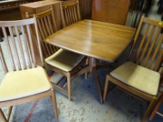 A good light oak Ercol extending dining table together with four matching splat back chairs