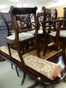A reproduction mahogany extending dining table with a set of six (4+2) matching cross back chairs