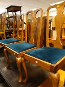 A set of four oak Queen Anne-style dining chairs