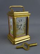 A FRENCH MINIATURE BRASS & PORCELAIN ENAMEL CARRIAGE CLOCK set with Roman numerals, the movement