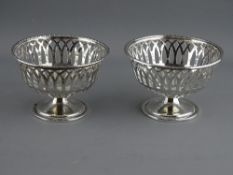 A PAIR OF SILVER PIERCED BASKET SWEETMEAT DISHES, 9 cms diameters, Birmingham 1894 & 1895, 2.8