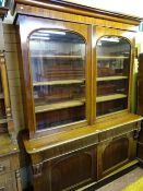 A VICTORIAN MAHOGANY TWO DOOR BOOKCASE CUPBOARD, the twin doors of the upper section having gently