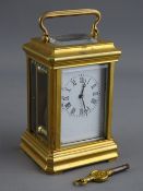 A FRENCH MINIATURE BRASS CASED CARRIAGE CLOCK having a white enamel dial set with Roman numerals,