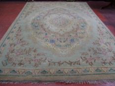 A VINTAGE TUFTED WOOLLEN CARPET having a central floral cartouche and spandrel corners with a single